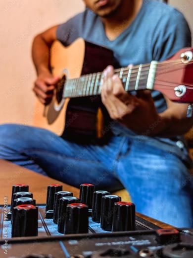 Un homme jouant de la guitare acoustique. © AdobeStock